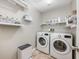 This laundry room features a washer, dryer, and shelving for storage at 1010 Leinhart Ct, Oviedo, FL 32765