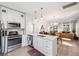 Bright kitchen featuring white cabinets, stainless appliances, and a view of the living room at 112 E Spruce St, Orlando, FL 32804
