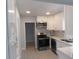 Modern kitchen with stainless steel appliances, white cabinets, and mosaic backsplash at 1600 Roosevelt Ave, Orlando, FL 32804
