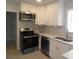 Modern kitchen featuring stainless steel appliances, white cabinets, and mosaic backsplash at 1600 Roosevelt Ave, Orlando, FL 32804