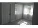 Bright living room with new gray vinyl flooring, white trim, and sheer curtains at 1600 Roosevelt Ave, Orlando, FL 32804