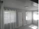 Bright living room with new gray vinyl flooring, white trim, and sheer curtains at 1600 Roosevelt Ave, Orlando, FL 32804