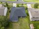 An aerial view shows a home with a well-maintained lawn, screened in porch, and modern roof in a suburban neighborhood at 1780 Nature Cove Ln, Clermont, FL 34711