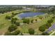 Aerial view showcases a scenic pond encircled by walking trails and lush greenery, perfect for outdoor recreation and relaxation at 1780 Nature Cove Ln, Clermont, FL 34711