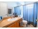 Bathroom with vanity, toilet, and shower with blue curtain at 1780 Nature Cove Ln, Clermont, FL 34711