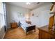 Well-lit bedroom with hardwood floors, a twin bed, and natural lighting at 1780 Nature Cove Ln, Clermont, FL 34711