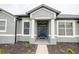 Inviting entryway with stately columns, fresh landscaping, and a stylish black front door at 1780 Nature Cove Ln, Clermont, FL 34711