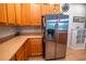 Kitchen features stainless steel refrigerator, wooden cabinets, and laminate countertop at 1780 Nature Cove Ln, Clermont, FL 34711