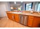 Kitchen view showcasing the sink, stainless steel dishwasher, and wood cabinets at 1780 Nature Cove Ln, Clermont, FL 34711