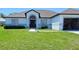Charming one-story home featuring a gray roof, attached garage, and well-maintained front yard at 1930 Dolphin Drive, Kissimmee, FL 34759