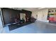 Spacious garage with home gym equipment, speckled floors, and a painted accent wall at 1930 Dolphin Drive, Kissimmee, FL 34759
