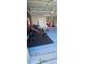 Equipped garage with a home gym setup, and speckled floors, with an access door at 1930 Dolphin Drive, Kissimmee, FL 34759