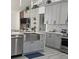Well-equipped kitchen featuring a stainless steel farmhouse sink, gray cabinetry, and modern appliances at 1930 Dolphin Drive, Kissimmee, FL 34759