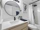 Well-lit bathroom featuring modern fixtures, round mirror, and shower with white subway tile at 2485 Lakeway Branch Dr # 2105, Orlando, FL 32839