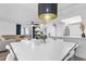 Elegant dining space with white table, decorative light fixture, and view of the living area at 2485 Lakeway Branch Dr # 2105, Orlando, FL 32839