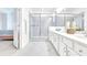 Modern bathroom with white cabinets, marble floors, glass shower, and double vanity at 2496 Rama Dr, Kissimmee, FL 34746