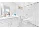 Bright white bathroom featuring a tub/shower combo, toilet, and a vanity with a large mirror at 2496 Rama Dr, Kissimmee, FL 34746