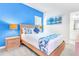 Bright bedroom featuring a comfortable bed, stylish lamps, and a vibrant blue accent wall at 2496 Rama Dr, Kissimmee, FL 34746