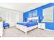 Comfortable bedroom with a blue accent wall, a king-size bed, and bright natural light at 2496 Rama Dr, Kissimmee, FL 34746