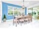 Bright dining room featuring blue accent wall, marble floors, and a wooden table with seating for six at 2496 Rama Dr, Kissimmee, FL 34746