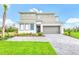 Contemporary two-story home with a manicured lawn and paved driveway leading to a two-car garage at 2496 Rama Dr, Kissimmee, FL 34746