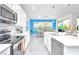 Beautiful kitchen with white cabinets, stainless steel appliances, marble floors, and view into the dining room at 2496 Rama Dr, Kissimmee, FL 34746