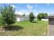 Large backyard with mature trees, a white fence, and plenty of green space at 257 Fig Ct, Kissimmee, FL 34759