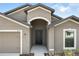 Welcoming front entrance with an arched doorway and a two-car garage at 257 Fig Ct, Kissimmee, FL 34759