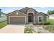 Charming home featuring a two-car garage and covered entryway for curb appeal at 257 Fig Ct, Kissimmee, FL 34759