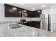 Modern kitchen features stainless steel appliances, granite countertops, and dark wood cabinets at 257 Fig Ct, Kissimmee, FL 34759