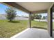 Covered patio overlooking a spacious backyard with a white fence for privacy and a lush green lawn at 257 Fig Ct, Kissimmee, FL 34759