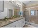 Elegant bathroom featuring double sinks with granite countertops, tiled shower, and modern fixtures at 2704 Lobelia Dr, Lake Mary, FL 32746