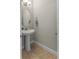 Stylish powder room with pedestal sink, modern fixtures, and neutral color palette for a clean, minimalist aesthetic at 2704 Lobelia Dr, Lake Mary, FL 32746