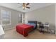 Cozy bedroom featuring natural light, a ceiling fan, and a dedicated desk workspace for convenience at 2704 Lobelia Dr, Lake Mary, FL 32746