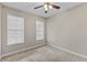 Comfortable bedroom featuring neutral walls, ceiling fan, and bright natural light from the dual windows at 2704 Lobelia Dr, Lake Mary, FL 32746