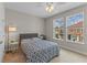 Bright bedroom with natural light, a comfortable bed, and a view of the neighborhood outside the windows at 2704 Lobelia Dr, Lake Mary, FL 32746