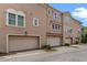 Three-story townhome with private garages, brick paver driveway, and neutral stucco exterior at 2704 Lobelia Dr, Lake Mary, FL 32746