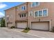 Three-story townhome with private garages, brick paver driveway, and neutral stucco exterior at 2704 Lobelia Dr, Lake Mary, FL 32746