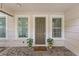Inviting front entrance featuring a welcoming welcome mat, potted plants, sidelight windows and neutral earth tone colors at 2704 Lobelia Dr, Lake Mary, FL 32746
