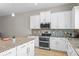 Bright kitchen with white cabinets, granite countertops, stainless steel appliances, and mosaic backsplash at 2704 Lobelia Dr, Lake Mary, FL 32746