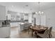 Bright kitchen featuring white cabinetry, granite counters, stainless appliances, an island and dining table at 2704 Lobelia Dr, Lake Mary, FL 32746