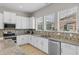 Kitchen features white cabinetry, granite countertops, a stainless steel sink, and natural light from multiple windows at 2704 Lobelia Dr, Lake Mary, FL 32746