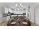 Bright kitchen with white cabinetry, granite counters, stainless appliances, pendant lighting and dining table at 2704 Lobelia Dr, Lake Mary, FL 32746