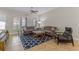 Bright living room features neutral walls, tile flooring, and blue patterned rug under gray couches with a ceiling fan at 2704 Lobelia Dr, Lake Mary, FL 32746