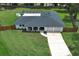 Aerial view of the single-story home with a long driveway, a manicured lawn, and an American flag at 300 Royal Palm Ct, Longwood, FL 32779