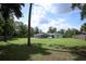 The large backyard includes a wooden fence, green grass, mature trees, and a screened-in pool at 300 Royal Palm Ct, Longwood, FL 32779