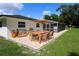 This backyard features a wooden patio set, a gas grill, green grass, and a screened in pool at 300 Royal Palm Ct, Longwood, FL 32779
