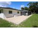 This backyard includes a brick patio with a screened-in pool, and green grass, and is surrounded by a white house at 300 Royal Palm Ct, Longwood, FL 32779