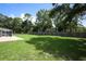 The backyard has green grass, a wooden fence, and a screened-in pool at 300 Royal Palm Ct, Longwood, FL 32779