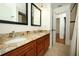 This bathroom features a double sink vanity with granite countertops and wood cabinets at 300 Royal Palm Ct, Longwood, FL 32779
